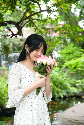 黑色小波点裙美女手捧花闻花香图片